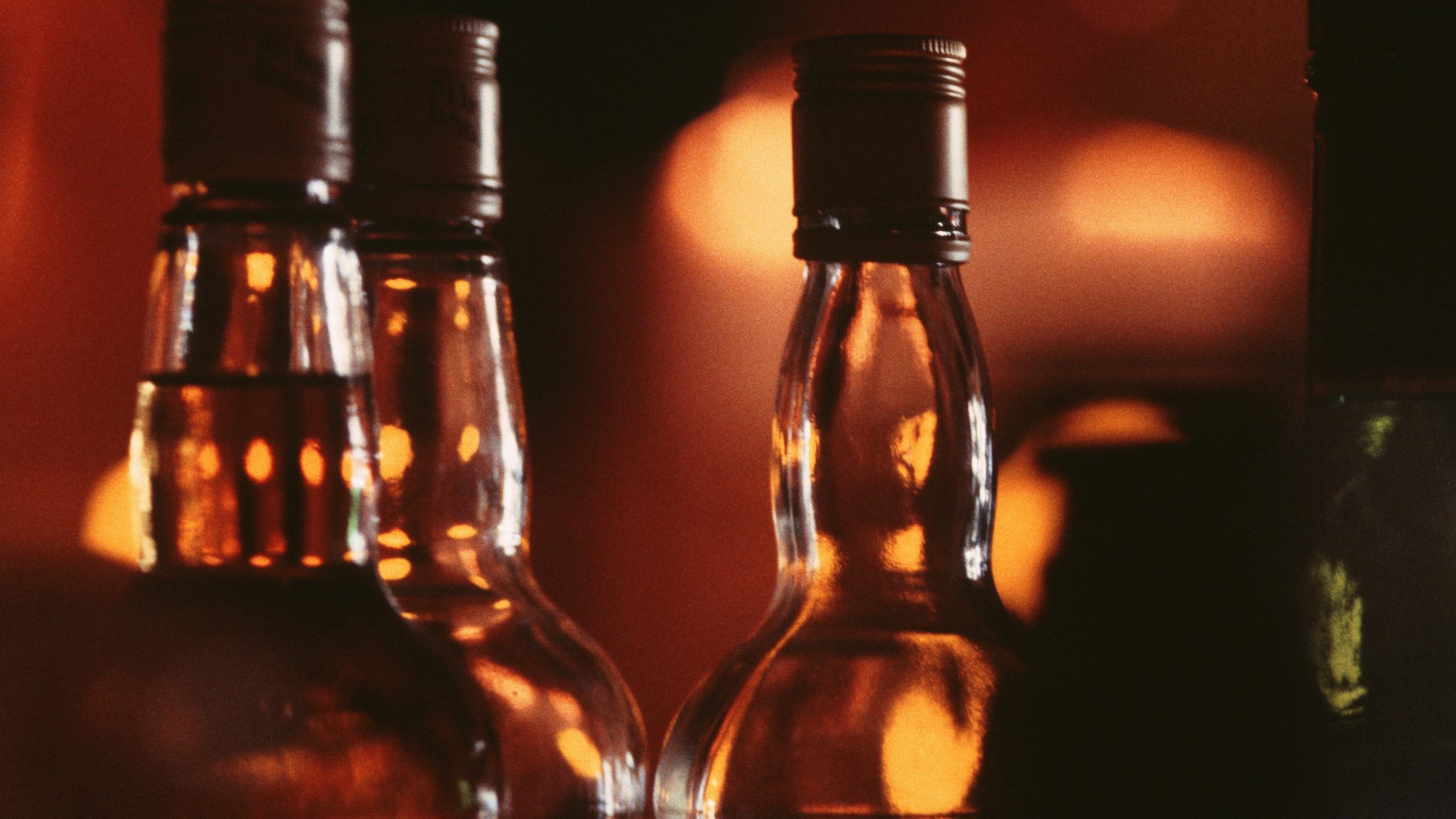 Bottles of alcohol side by side on bar, close-up